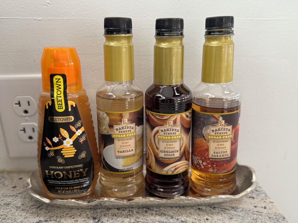 Four bottles of sugar-free syrups on a metal tray.