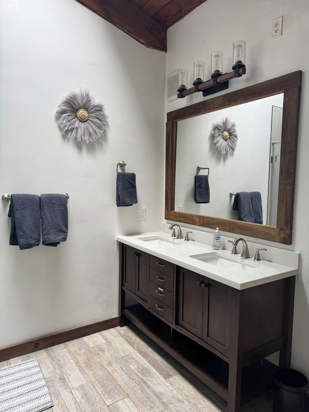 A bathroom with two sinks, a large mirror, and decorative wall art.